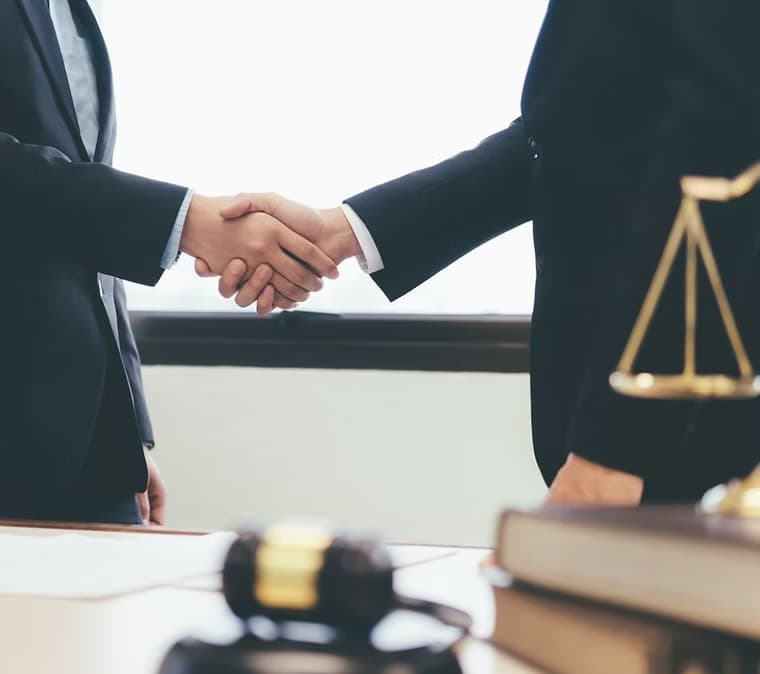 Professional handshake beside legal scales